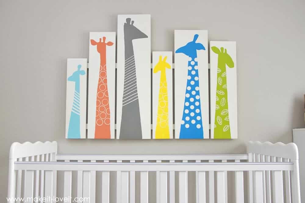 colorful giraffe silhouettes hanging above a baby crib