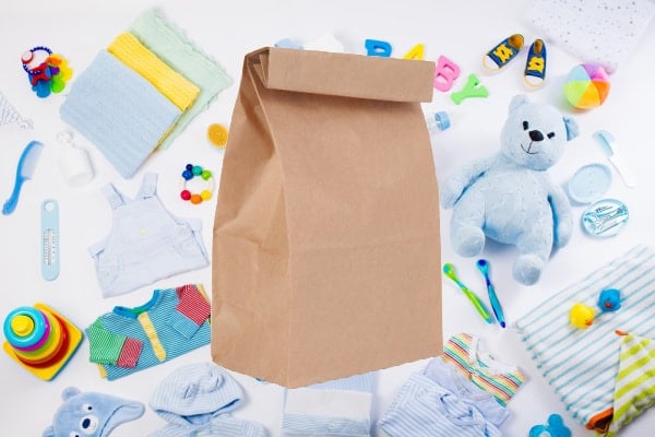 brown paper bag surrounded by baby items