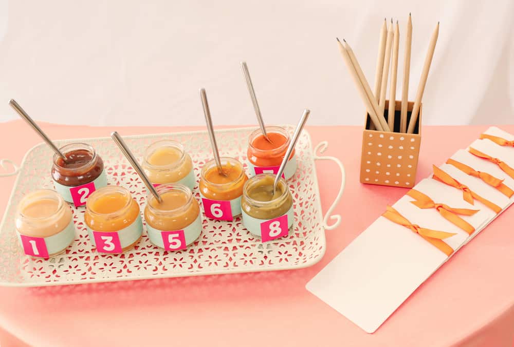 Jars with different puree on table. Game "Guess taste" for baby shower