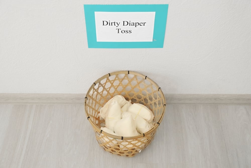 Basket with diapers on floor for game at baby shower party
