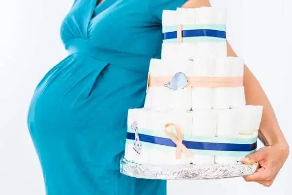 pregnant woman holding a diaper cake